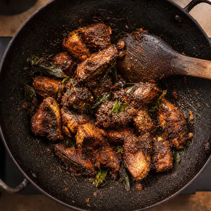 Step 4: masala cooked dry in a wide iron kadai